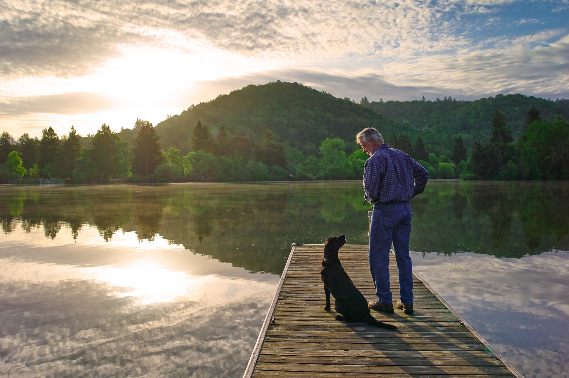 A-man-and-a-Black-Labrador-on-a-lake-dock
